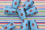 Blue 9 oz paper cups with repeating double bass pattern on striped background